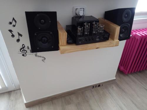 a room with a wall with speakers and a table at AltaValle Holiday Home, monolocale Pink e bilocale Lime in Chiesa in Valmalenco
