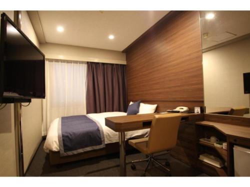 a hotel room with a bed and a desk and a television at Hotel Il Credo Gifu - Vacation STAY 84585 in Gifu