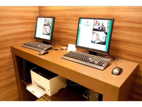 a desk with two computer monitors and a keyboard and mouse at Hotel Il Credo Gifu - Vacation STAY 84631 in Gifu