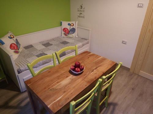 a small room with a wooden table and a bed at AltaValle Holiday Home, monolocale Pink e bilocale Lime in Chiesa in Valmalenco