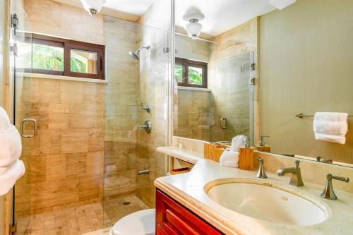 un baño con lavabo y ducha en Stylish Split-Level Condo with a Shaded Terrace, Direct Beach Access, and Resort-Style Community Amenities, en Playa Flamingo