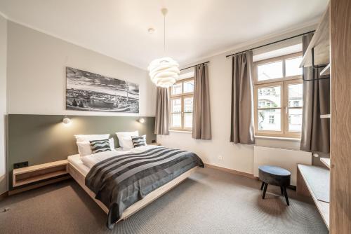 a bedroom with a bed and a large window at Hotel Am Markt in Munich