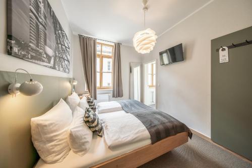 a bedroom with a bed with white sheets and pillows at Hotel Am Markt in Munich