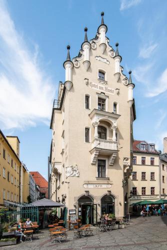 a tall building with a clock tower on a street at Hotel Am Markt in Munich