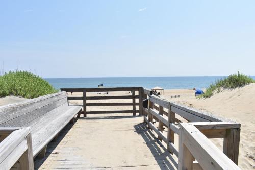 a wooden pathway to the beach with the ocean in the background at Blue Heron Motel in Nags Head