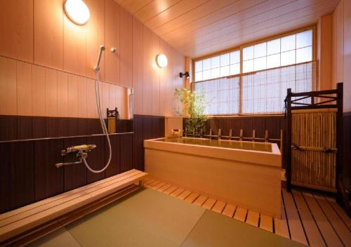 a bathroom with a bath tub and a shower at Dai Onsen Matsudaya Ryokan - Vacation STAY 67479 in Hanamaki
