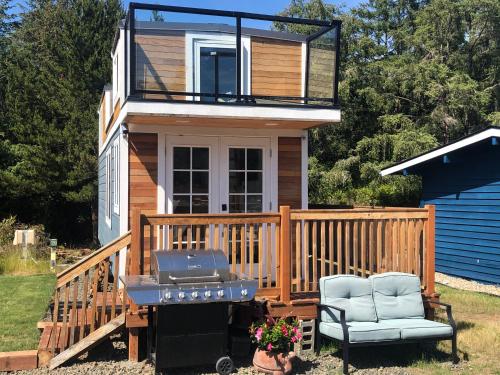 a house with a grill and a chair on a deck at Pacific Dunes Resort in Copalis Beach