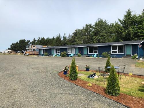 a parking lot with chairs and trees in front of a motel at Pacific Dunes Resort in Copalis Beach