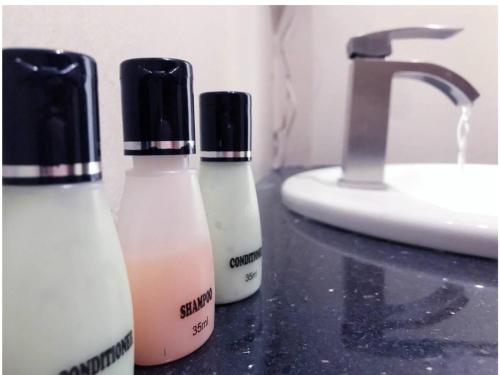two bottles of soap on a counter next to a sink at Bayfront in Weligama