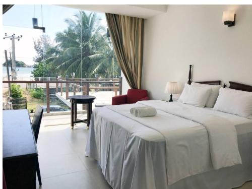 a bedroom with a bed and a large window at Bayfront in Weligama