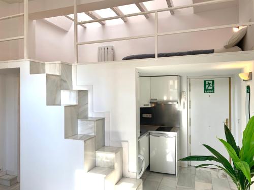 een witte woonkamer met een wenteltrap bij Apartamentos Puerta del Sol-Rastro in Madrid