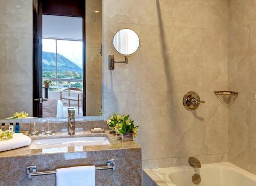 a bathroom with a sink and a tub and a mirror at Hotel Estelar Yopal in Yopal