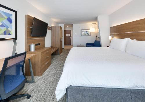 a hotel room with a bed and a desk and a tv at Holiday Inn Express & Suites San Antonio NW near SeaWorld by IHG in San Antonio