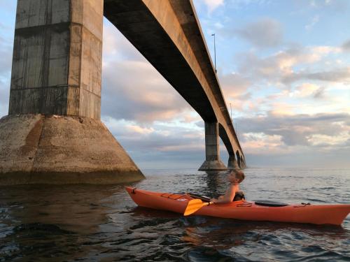 a boy in a kayak in the water under a bridge at Newly Renovated Confederation Bridge View Cottages in Borden