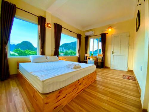 una camera da letto con un grande letto e ampie finestre di Ha Lan Homestay a Ninh Binh