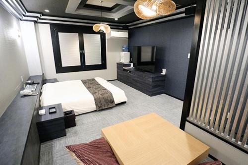 a bedroom with a bed and a television in it at Lex Suwa (Adult Only) in Suwa