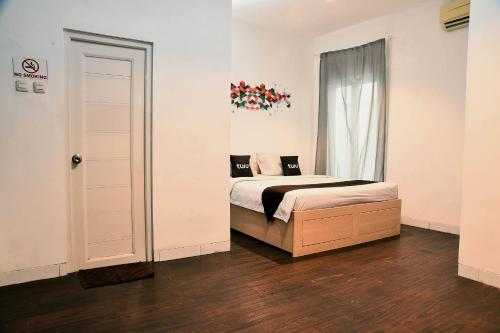 a bedroom with a bed and a window at Tuju Abuserin Syariah in Jakarta