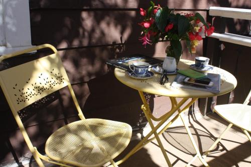 a table and chair on a balcony with a vase of flowers at Northland Lodge in Waterton Park