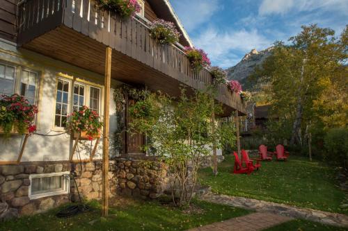 a house with red chairs in the yard at Northland Lodge in Waterton Park
