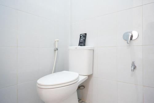 ein Bad mit einem weißen WC in einem Zimmer in der Unterkunft RedDoorz near Padang Golf Adisucipto in Potrojayan