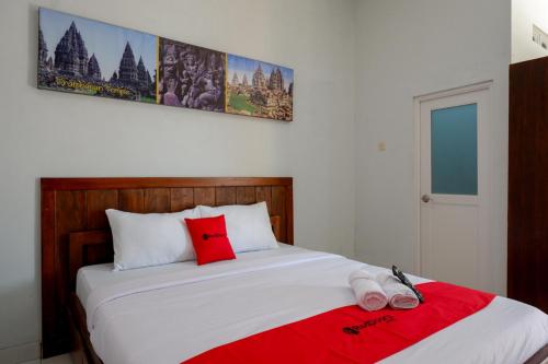 a bedroom with a bed with two slippers on it at RedDoorz near Padang Golf Adisucipto in Potrojayan