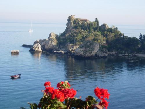 a house on a small island in the water at Jonic Hotel Mazzarò in Taormina