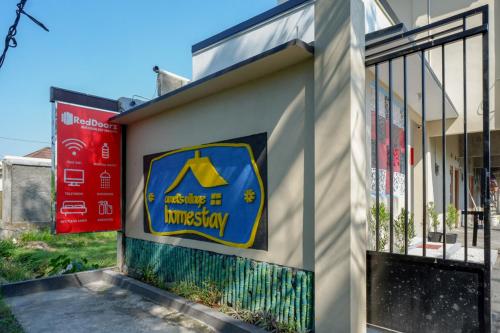 a building with a sign on the side of it at RedDoorz near Padang Golf Adisucipto in Potrojayan