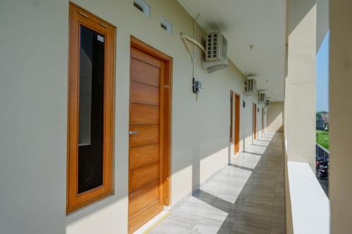 a hallway of a house with a wooden door at RedDoorz near Padang Golf Adisucipto in Potrojayan