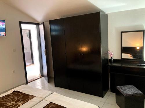 a room with a black cabinet and a mirror at Guest house Dragović in Sveti Stefan