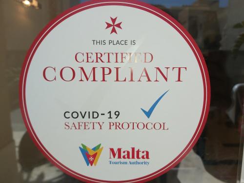 um sinal para um restaurante certificado numa janela em Tropicana Hotel em St. Julian's