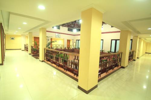 a hallway of a building with columns and books at Hotel Preethi Classic Towers in Ooty