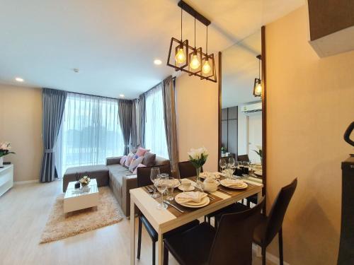 a living room with a dining table and a couch at Luxury Family Suite Two Bedroom At Nimman Maya 605RY in Chiang Mai