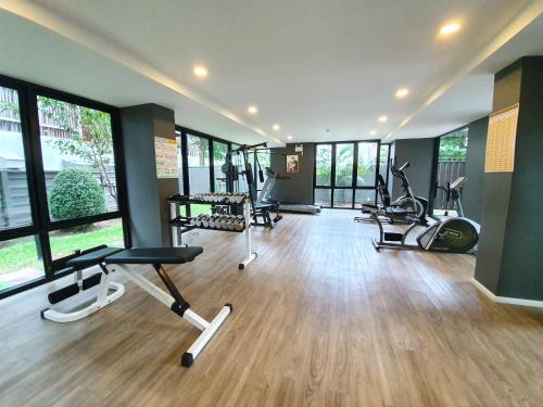 a gym with treadmills and exercise equipment in a room with windows at Luxury Family Suite Two Bedroom At Nimman Maya 605RY in Chiang Mai