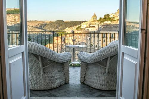 a balcony with chairs and a view of a city at Bed and Breakfast Terra del Sole Ibla in Ragusa