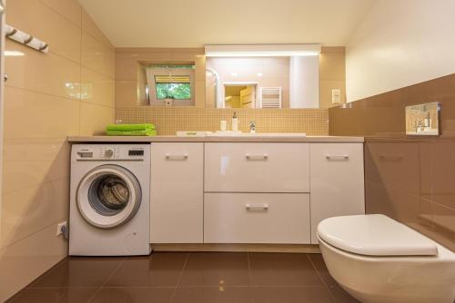 a bathroom with a washing machine and a sink at S11 in Palanga