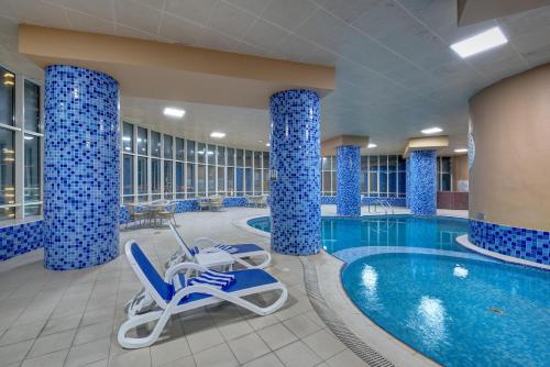 a pool in a hotel with blue columns at Aryana Hotel in Sharjah