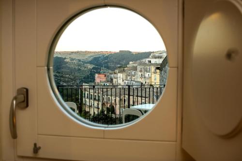 a round window with a view of a city at Bed and Breakfast Terra del Sole Ibla in Ragusa