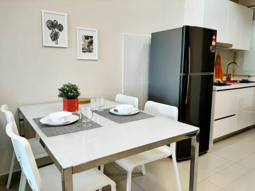 a kitchen with a white table and a black refrigerator at Homey Galleria Suite A 10 12 in Seri Kembangan