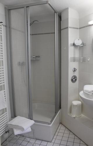 a bathroom with a shower with a toilet and a sink at Pension Brinn in Berlin