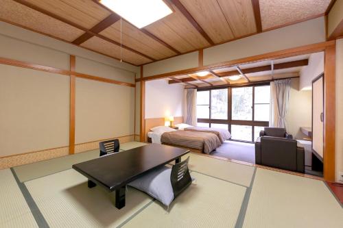 Zimmer mit einem Schlafzimmer, einem Bett und einem Tisch in der Unterkunft Ichiryukaku Honkan in Nikko