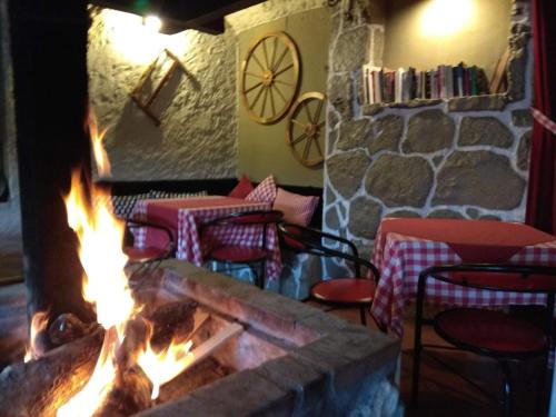 un foyer dans un restaurant avec des tables et des chaises dans l'établissement Rural Arco Iris, à Cuenca