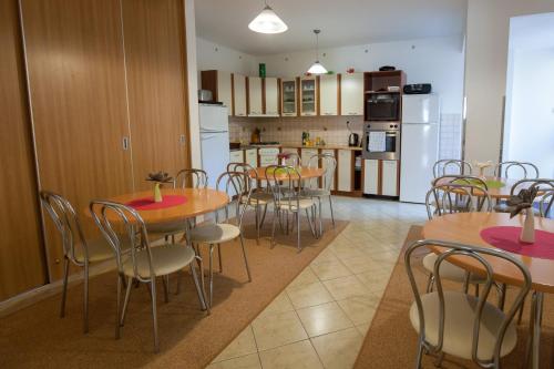 a dining room with tables and chairs and a kitchen at Privat Julia in Vrbov