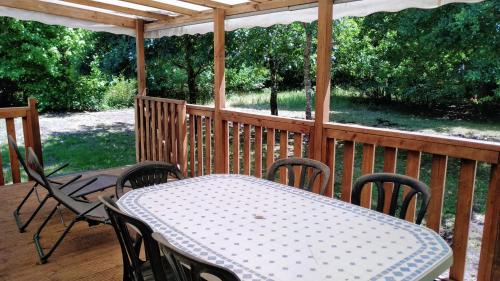 porche con mesa y sillas en la cubierta en Camping baradis, en Commensacq