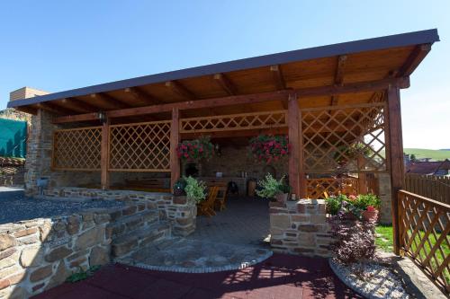 a large wooden pavilion with a table and flowers at Privat Julia in Vrbov