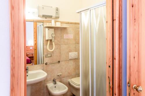 a bathroom with a toilet and a sink and a mirror at Camere da Mirella in Lazise