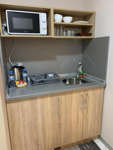 a kitchen with a sink and a microwave at Apartments K&M Sandanski in Sandanski