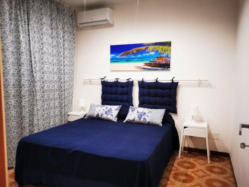 シラクーサにあるShort Lets Villa al Mare Siracusaのベッドルーム1室(青いベッド1台付)