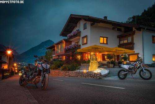 two motorcycles parked in front of a building at Hotel Sonnleiten in Bruck am Ziller