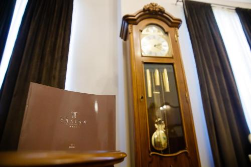 a grandfather clock sitting next to a window at Grand Hotel Traian in Iaşi