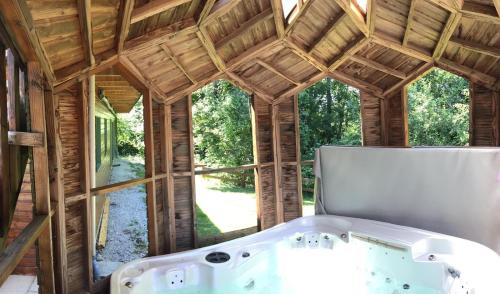 ein Badezimmer mit Badewanne in einem Holzhaus in der Unterkunft Les sentiers du lac in Sorèze